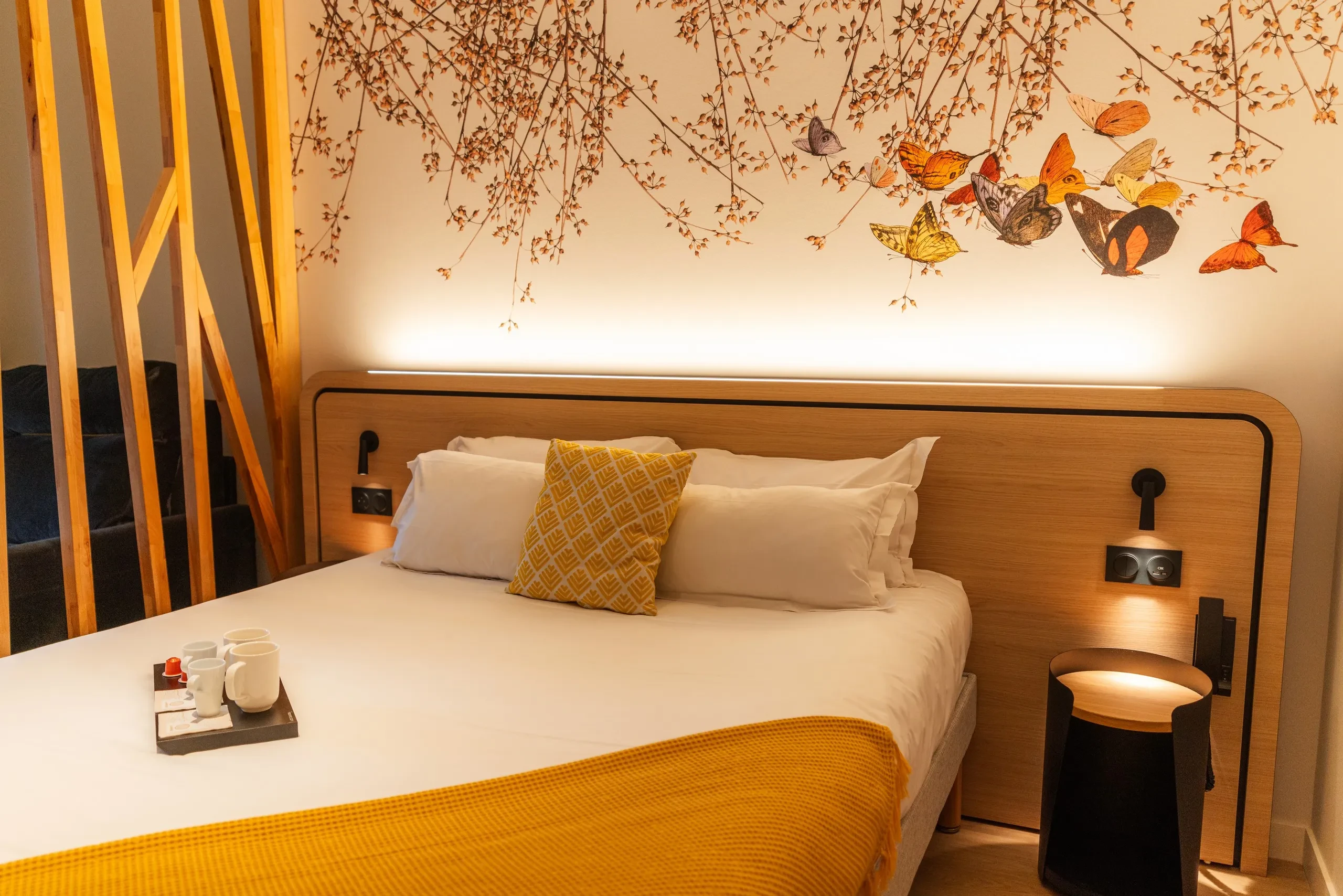 Chambre d'hôtel avec décoration murale de papillons.